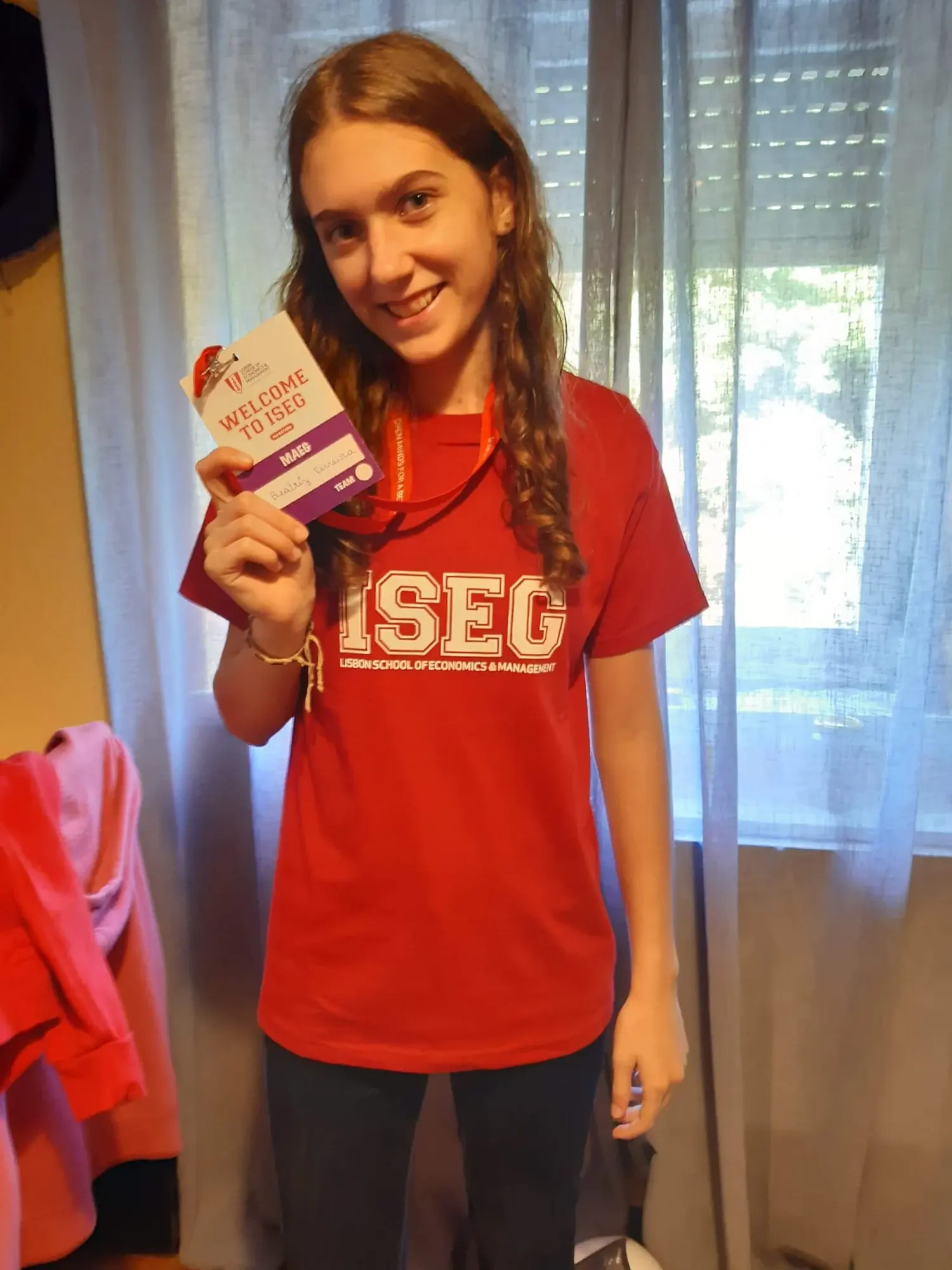 Beatriz Ferreira wearing an ISEG T-shirt and holding a Welcome to ISEG badge.